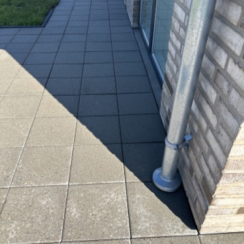 Fliserens af gangsti langs hus med markant forbedret overflade