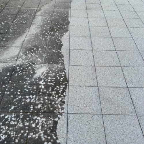 Halvt renset terrasse efter fliserens med tydelig overgang mellem snavs og rent område