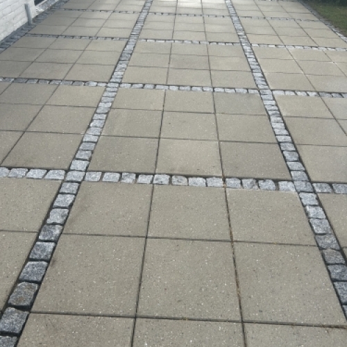 Fliserens af stor terrasse med dekorative belægningsbånd og ensartet resultat