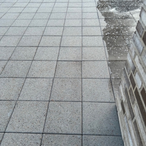 Fliserens af stor terrasse med synlig farveforskel mellem renset og urenset område