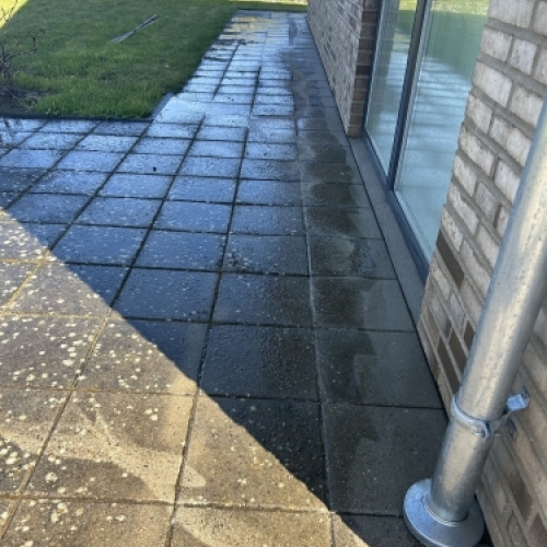 Fliserens i gang på terrasse med professionel højtryksrensning