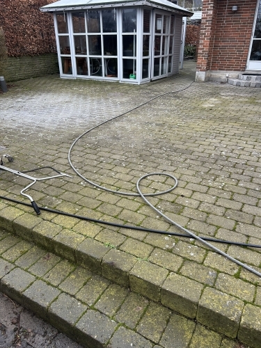 Fliserens i gang med højtryksrensning af terrassebelægning