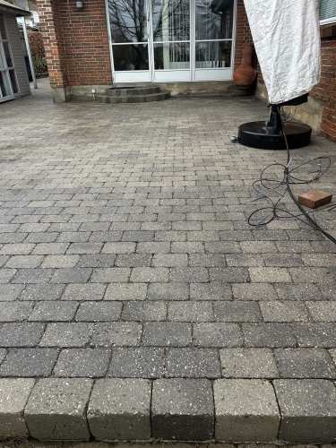 Før og efter fliserens med tydelig forskel på renset og urenset belægning