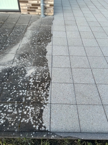 Halvt renset terrasse efter fliserens med tydelig overgang mellem snavs og rent område