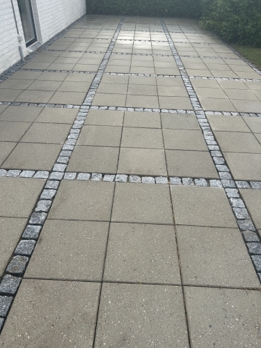 Fliserens af stor terrasse med dekorative belægningsbånd og ensartet resultat