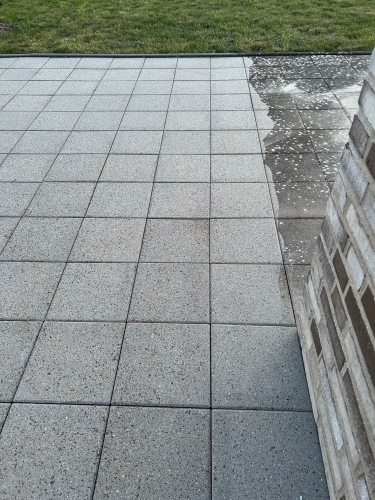 Fliserens af stor terrasse med synlig farveforskel mellem renset og urenset område